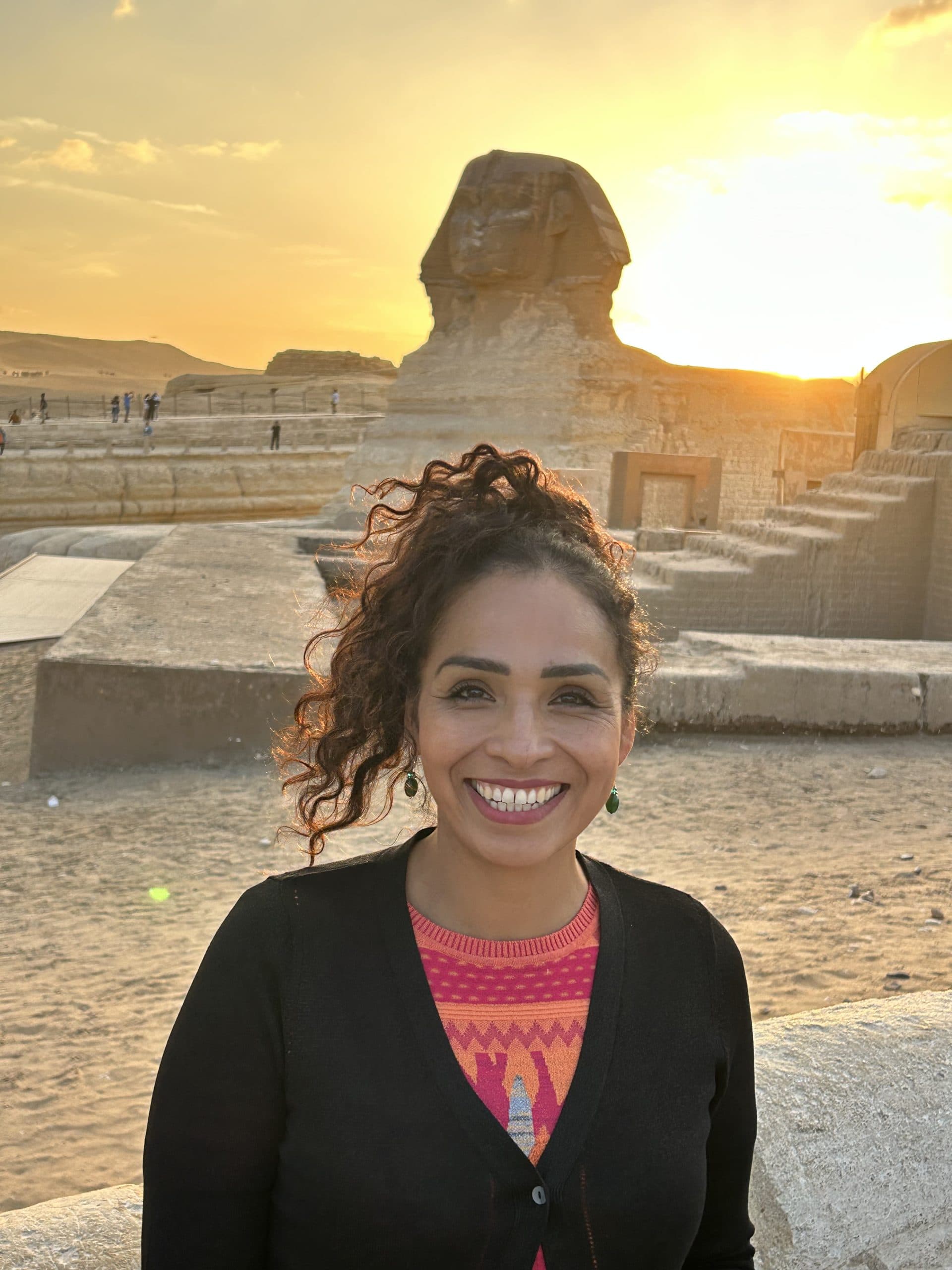 Gisella Grados smiling at sunset in front of the Sphinx in Giza, Egypt